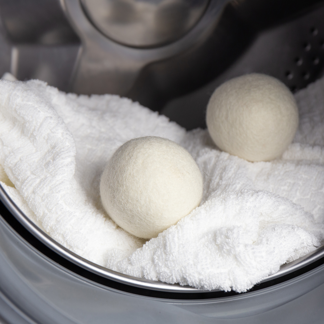 Wool dryer balls in a dryer drum, cream and off-white spheres