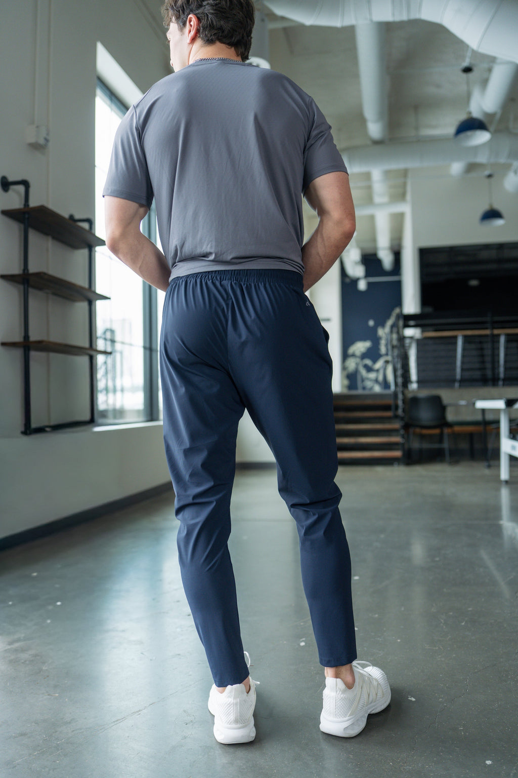 Back view of navy grit V2 pants with elastic waist and tapered leg