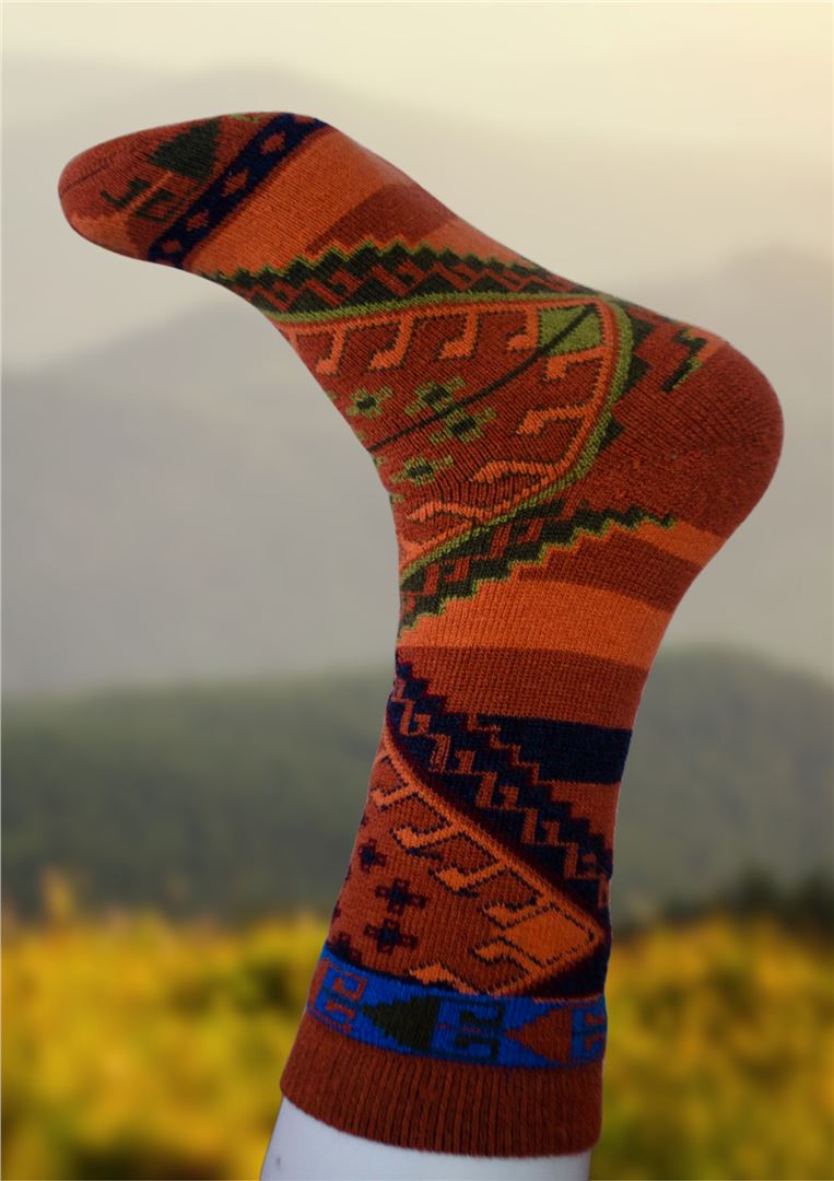 Rust orange alpaca sock with green and blue geometric knit design