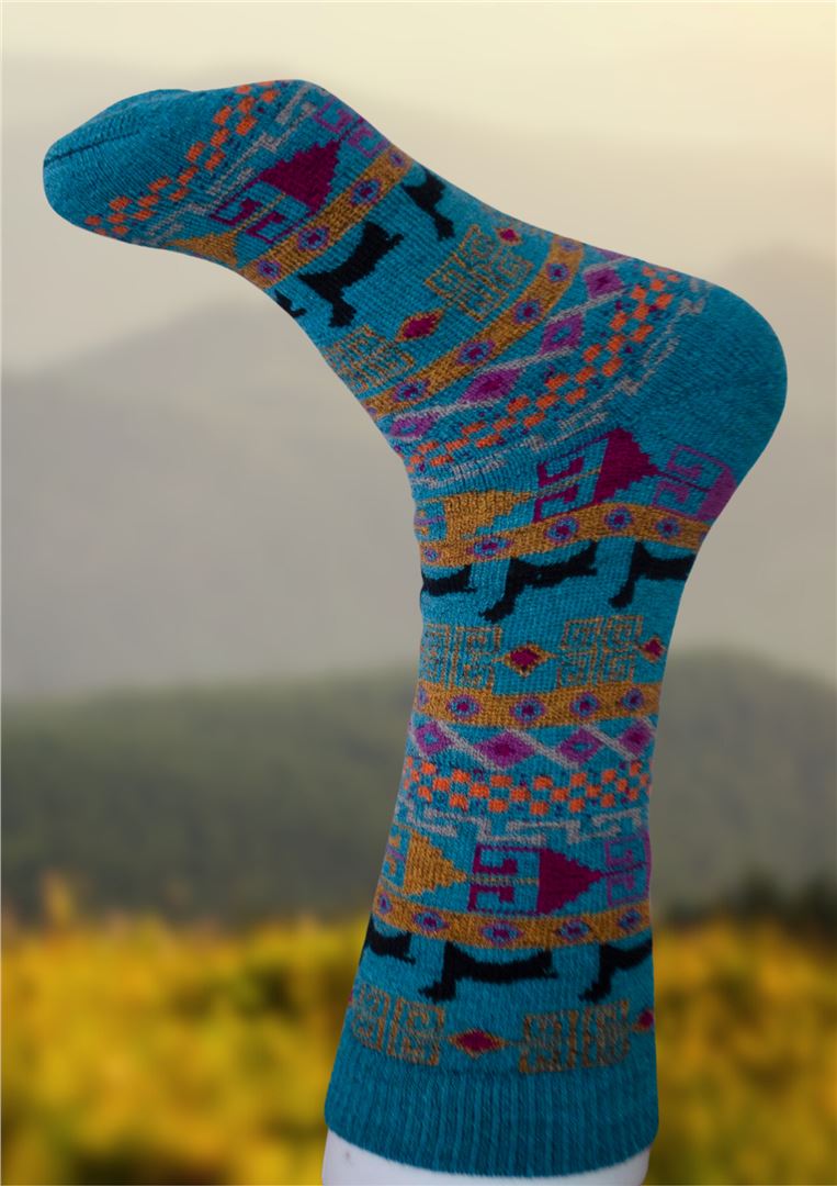 Alpaca socks in teal blue with multicolor geometric pattern, dark toe and heel.