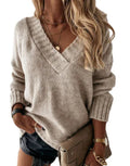 Oversized cashmere sweater in oatmeal, V-neck, long sleeves with ribbed cuffs.