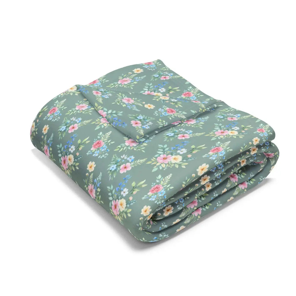 Pastel floral fleece blanket folded, teal-green with multicolor spring flowers and pink accents