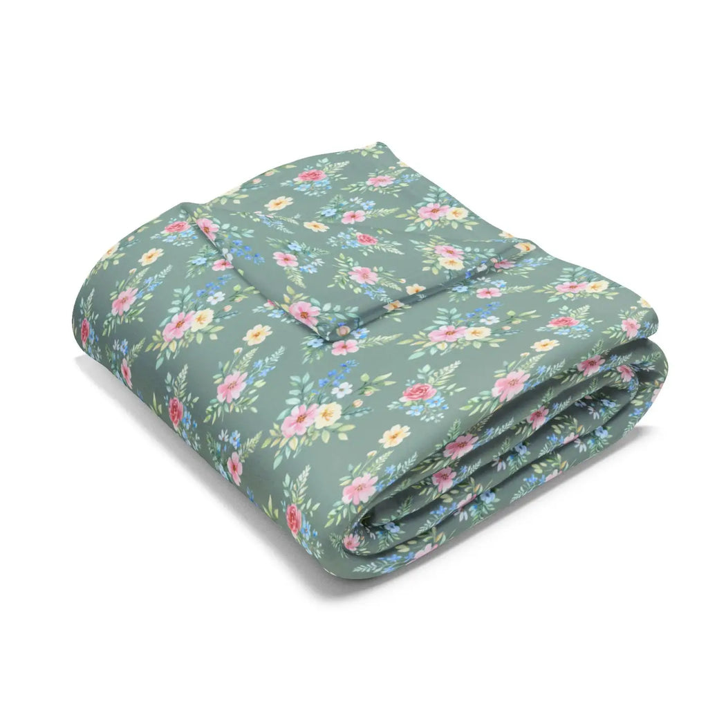 Floral pastel fleece blanket, folded: green base with pink, blue, and yellow flowers