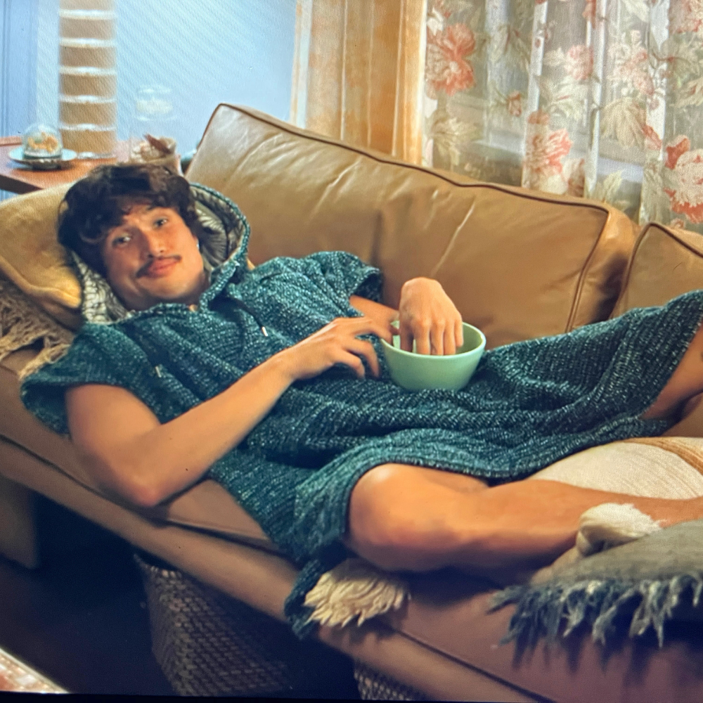 Blue hooded blanket robe worn lounging style with soft textured knit