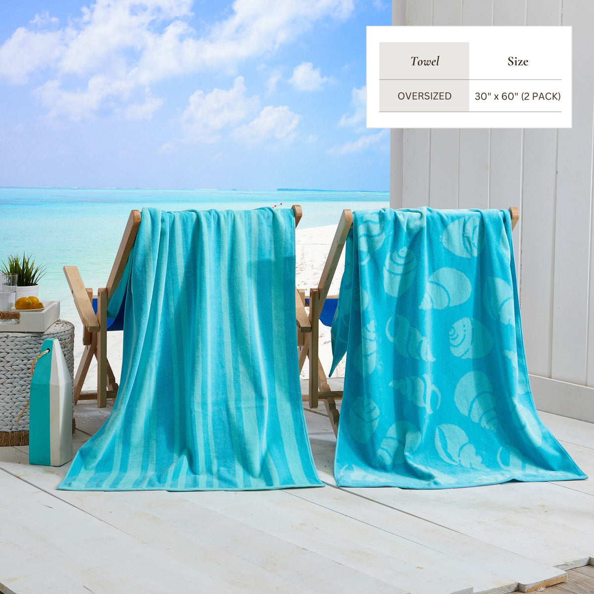 Turquoise cotton velour beach towel with subtle sea-life pattern, draped over chairs