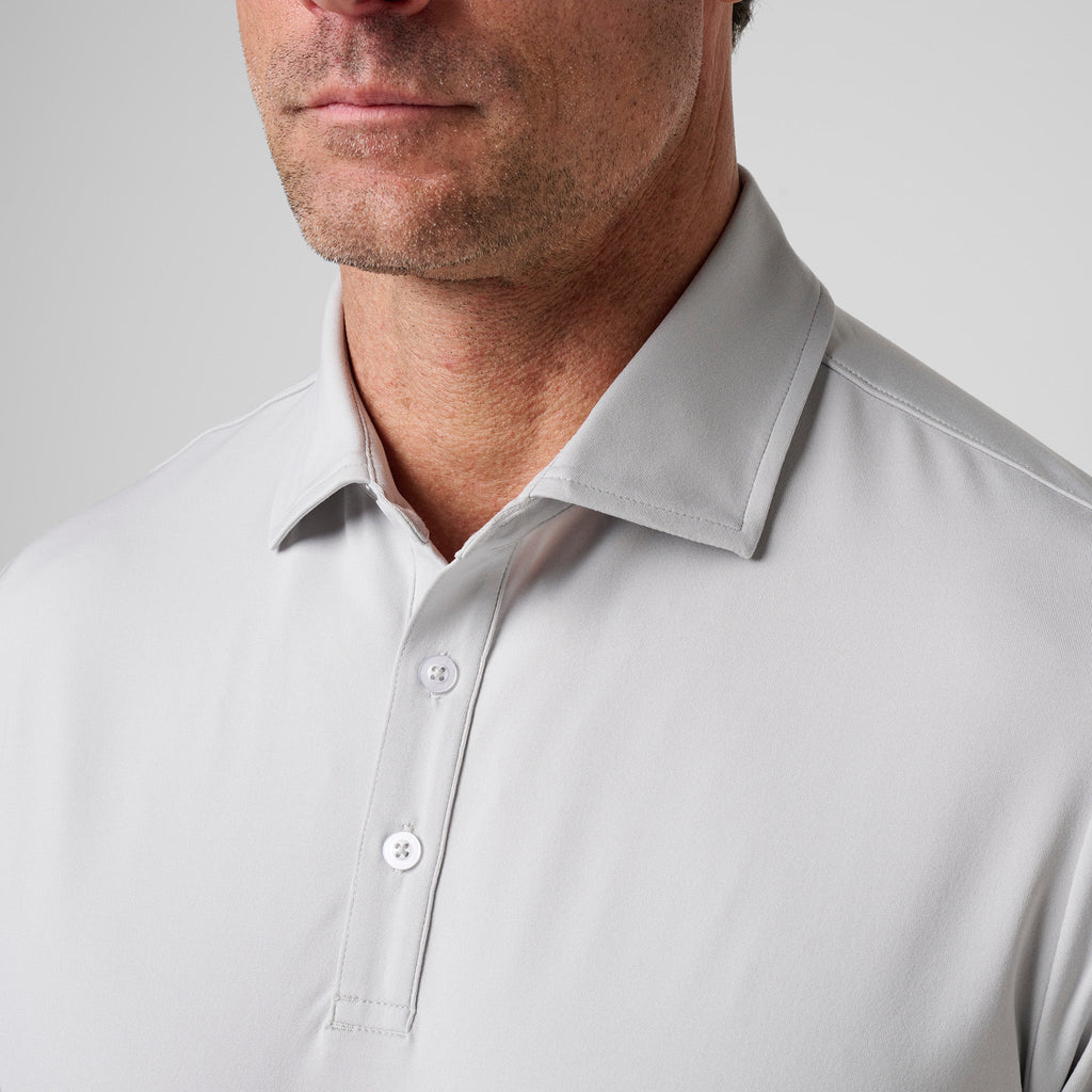 Ash gray polo close-up with short button placket and fold-over collar.