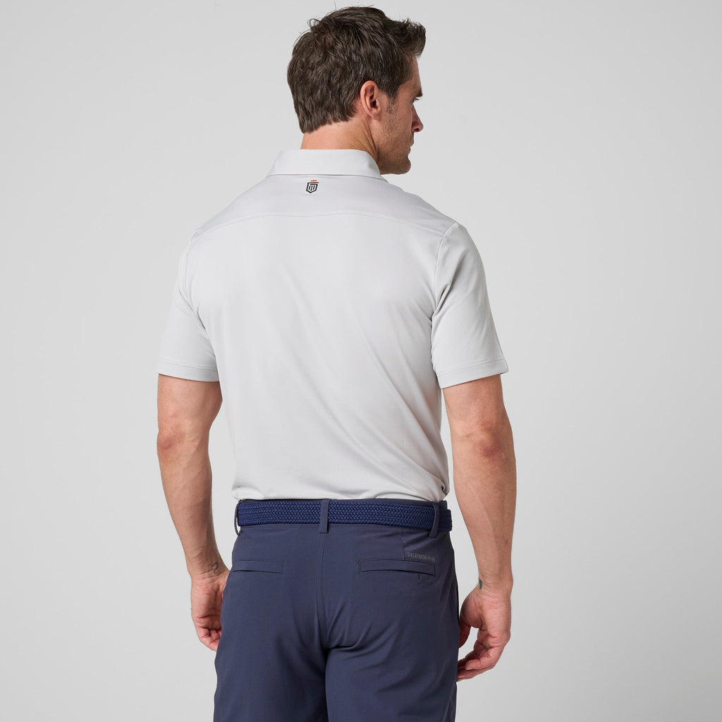 Ash gray athletic polo back view with short sleeves and logo on the collar.
