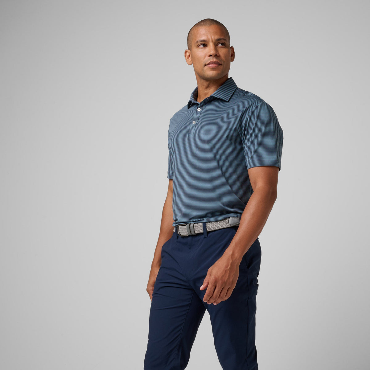 Men's athletic polo shirt in storm blue with striped pattern, button placket and collar.
