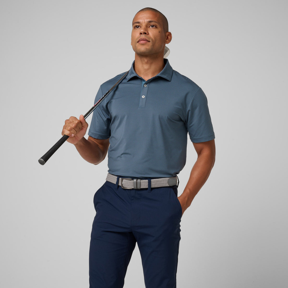 Storm blue athletic polo with striped texture, short sleeves, and collared button placket.