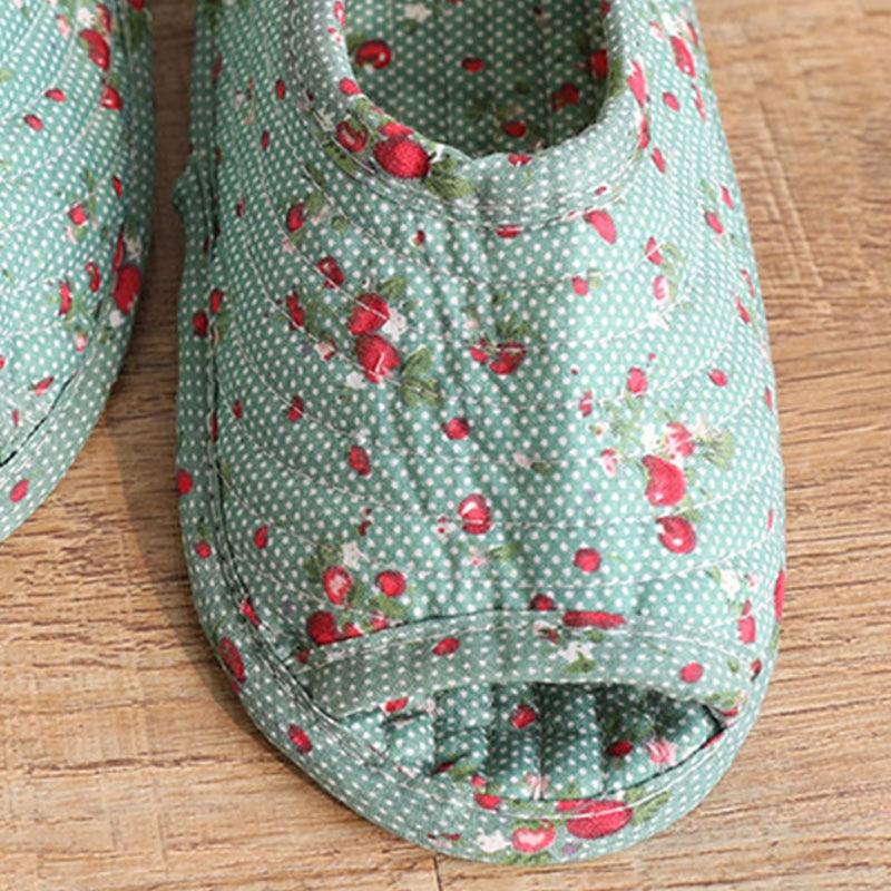 Close-up of women's teal indoor slippers with red berry pattern and cushioned toe sole