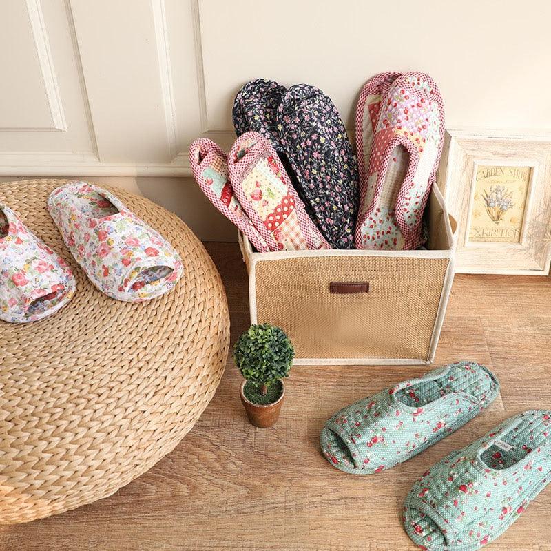 Women's indoor slippers assortment in floral prints, shown in a storage tray and basket