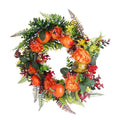 Autumn wreath with orange pumpkins, orange flowers, red berries, and green fern leaves