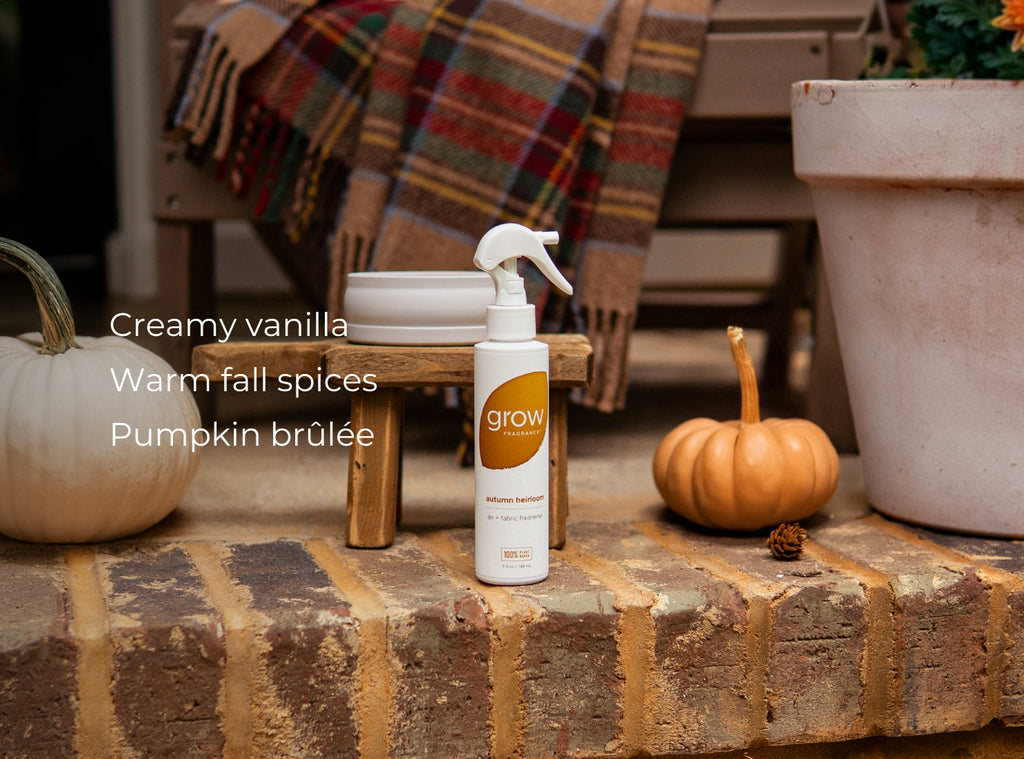 Air and fabric spray bottle with 'grow' logo on wood block with pumpkins and spice