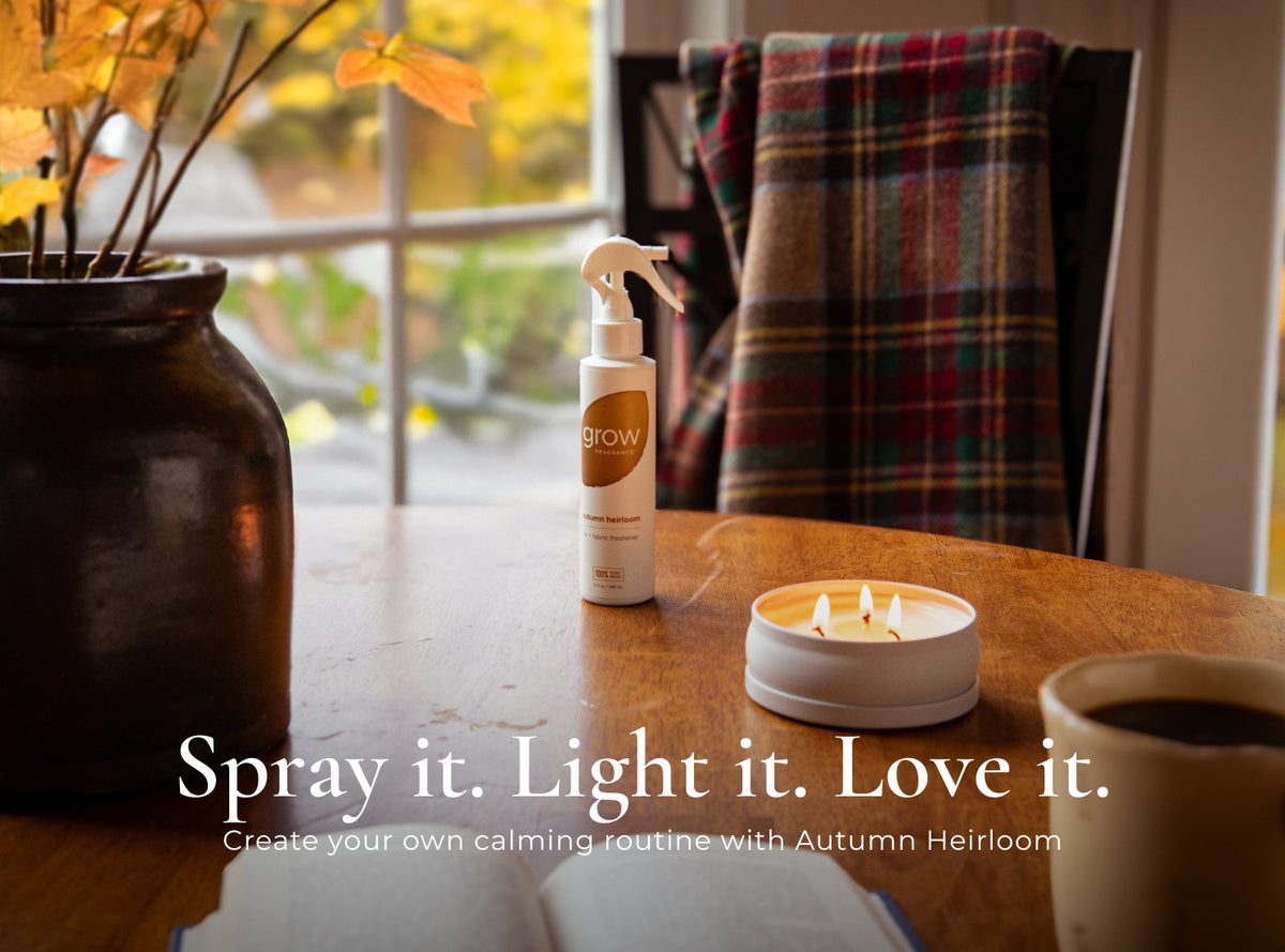 Air and fabric spray bottle with 'grow' logo next to candle and autumn decor
