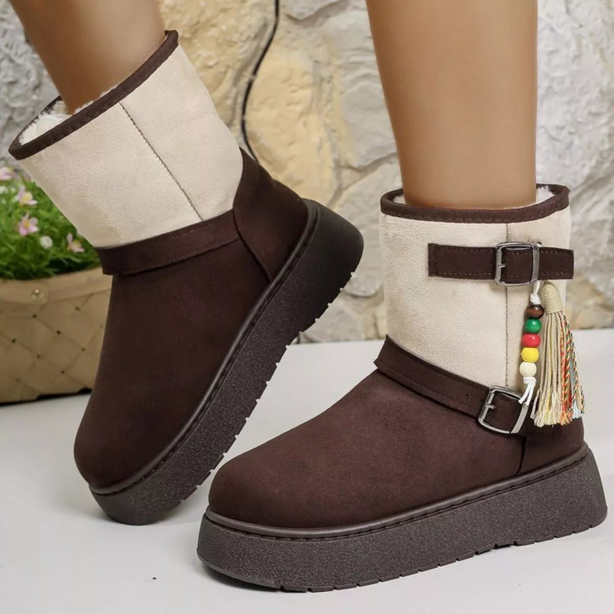 Pair of brown ankle boots with white cuff, tassel, double buckles, lug sole