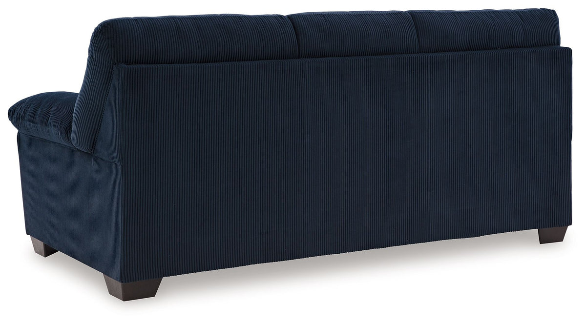 Dark blue corduroy sofa side view with rounded arms and block feet