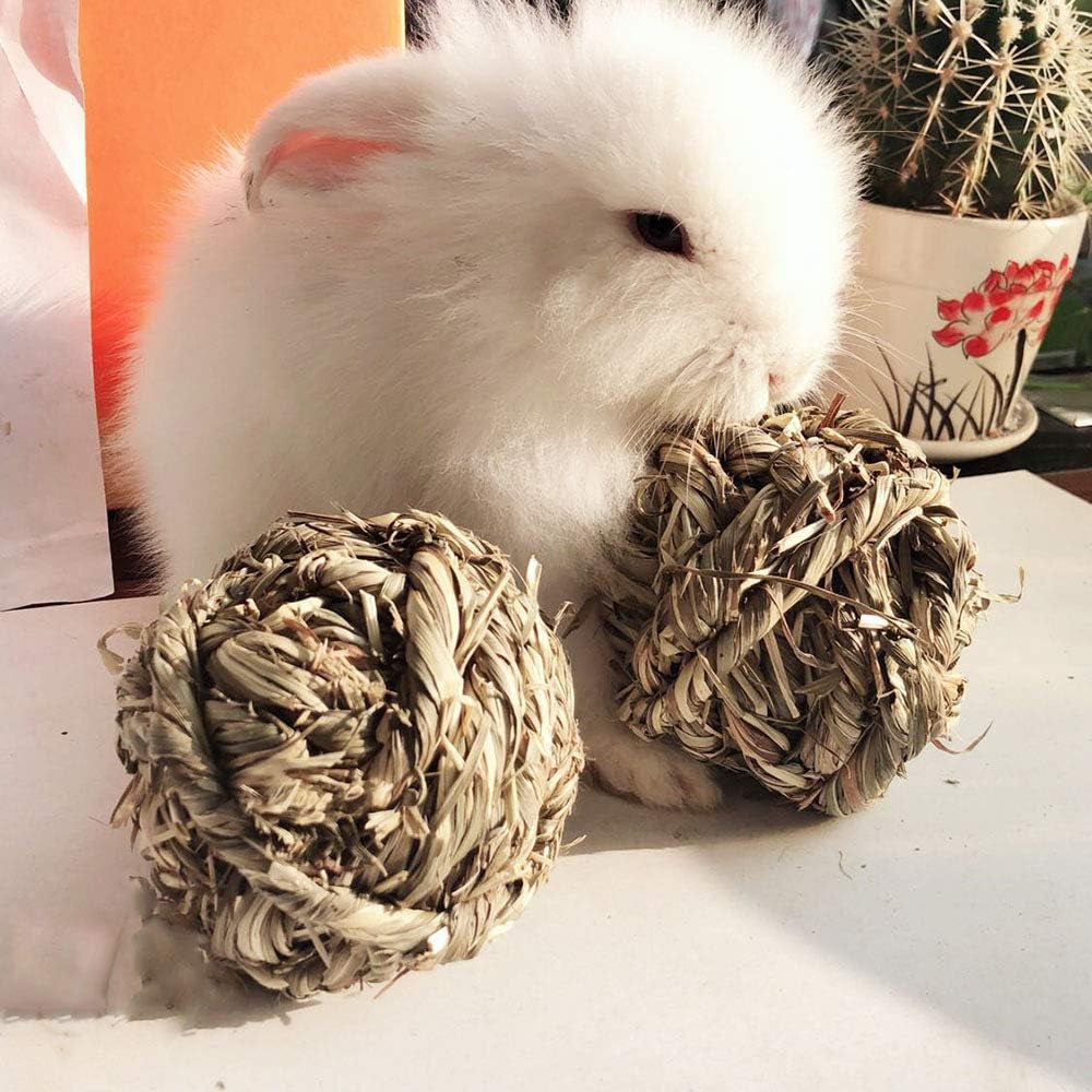 Two pale braided grass chew balls beside a rabbit