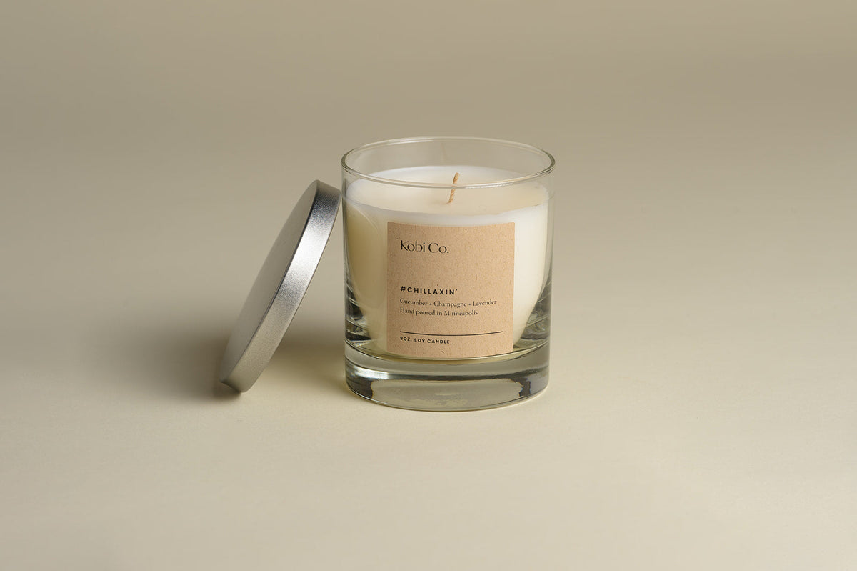 Luxury candle in clear glass jar with cream wax, gold wick cross, silver lid