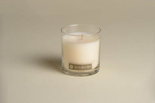 Luxury candle in clear glass jar with cream wax and front label