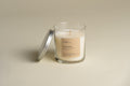 Bookworm luxury candle in clear glass jar with white wax and small wick; lid beside it.