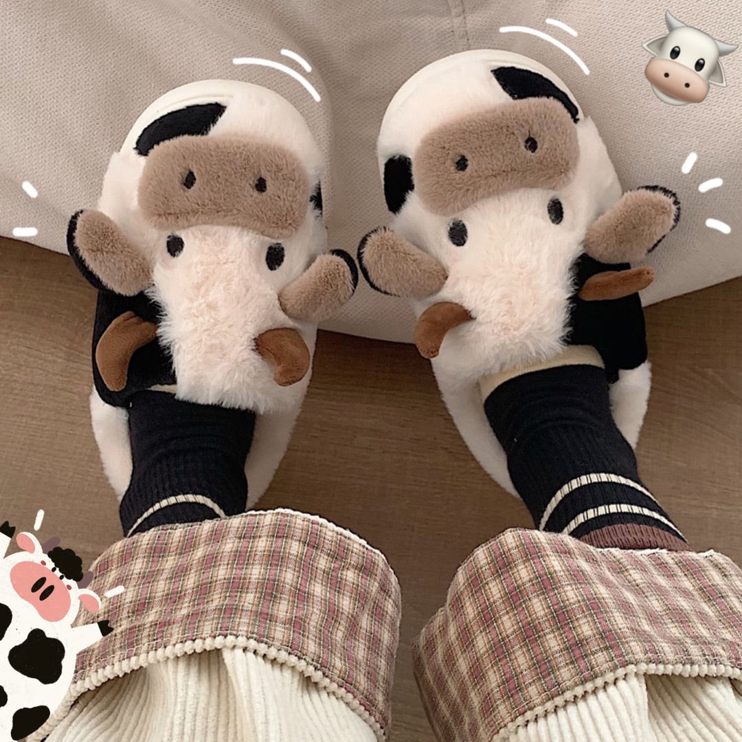 Pair of plush cow slippers with black-and-white faces and brown ears, cozy winter fit