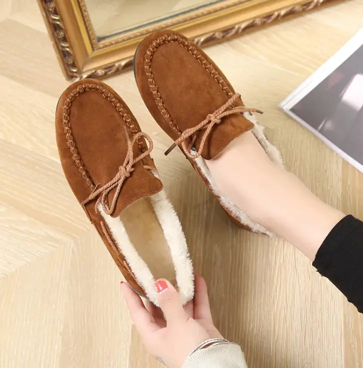 Brown plush slip-on moccasin flats with lace-up vamp and fuzzy white interior lining