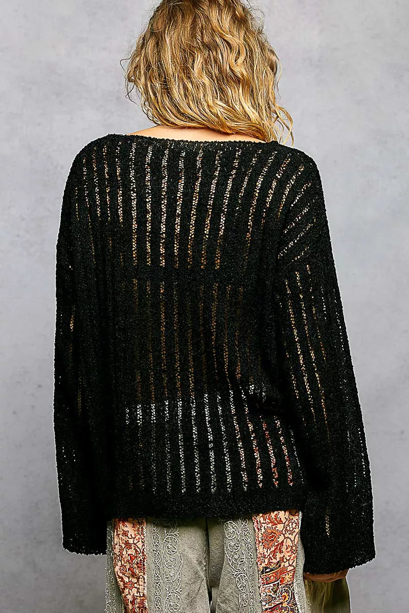 Back view of black open-weave round-neck long-sleeve sweater, textured knit.