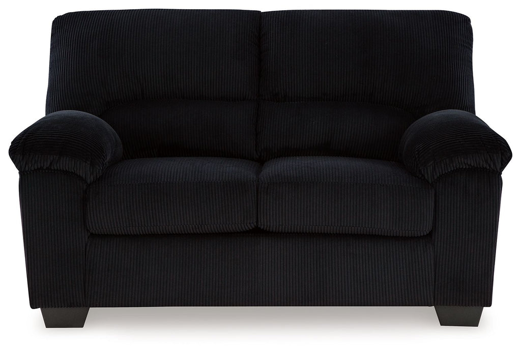 Upholstered loveseat in dark fabric with rolled arms, tufted back, and two seat cushions