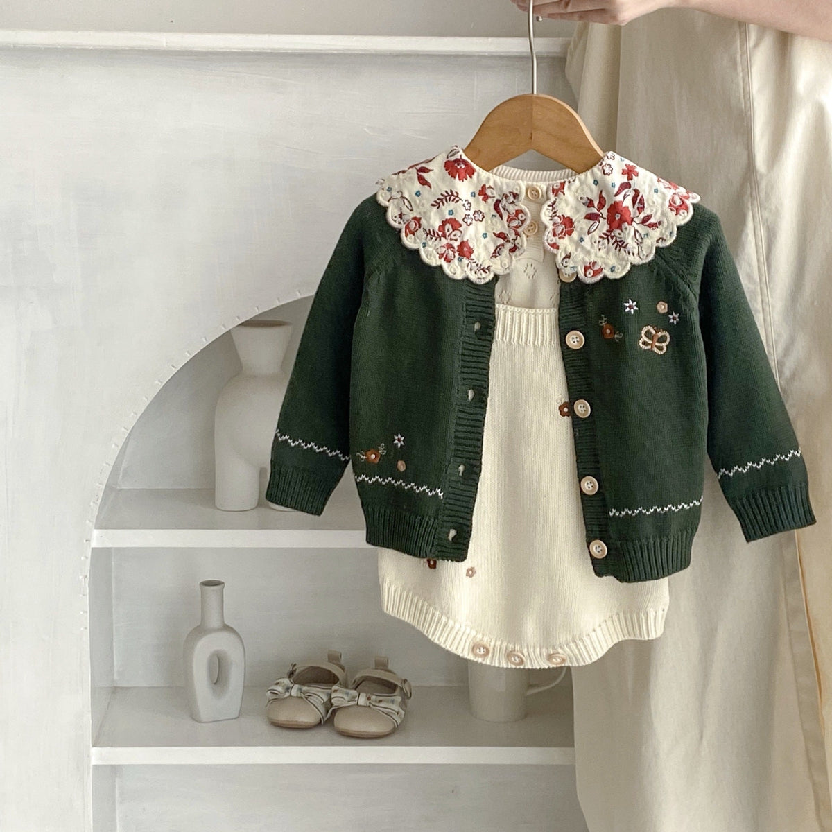 Infant dark green cardigan with red floral collar over cream knit romper with button placket