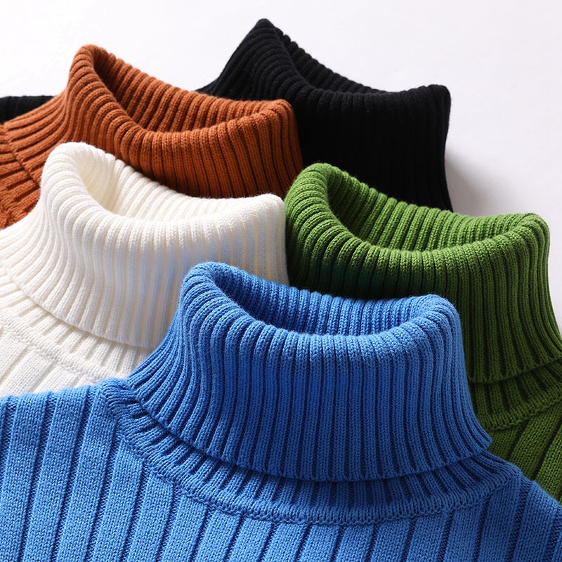 Ribbed turtleneck sweaters stack in blue, green, black, white, and brown.
