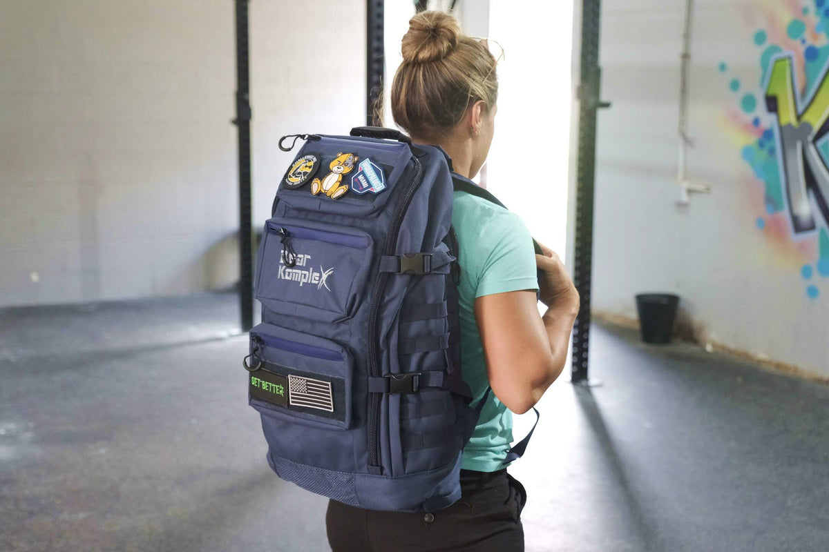 BKX military backpack in navy blue, worn on person with front pockets and straps