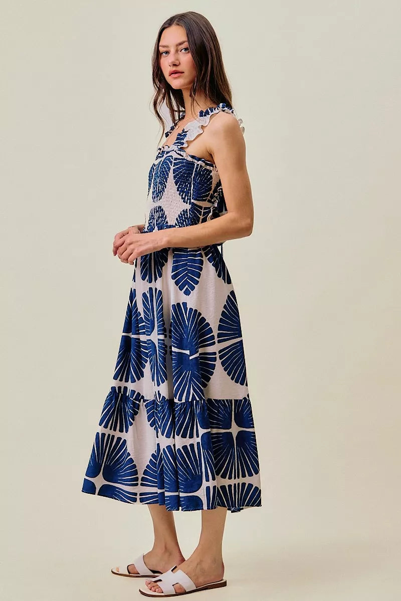 Side profile of navy and white abstract print tiered midi dress with ruffled straps