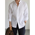 Men's white linen button-up shirt with long sleeves and front button placket