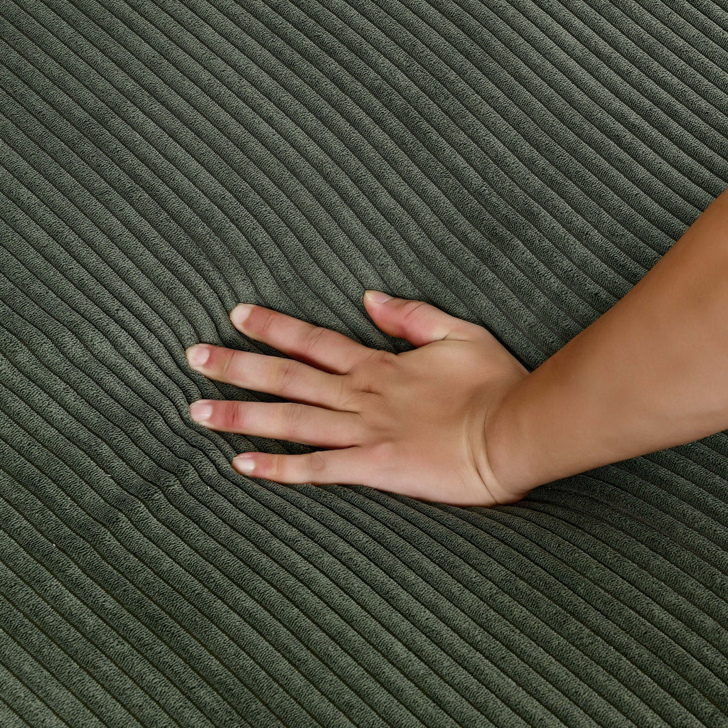 Dark green corduroy upholstery close-up with vertical ribbed texture