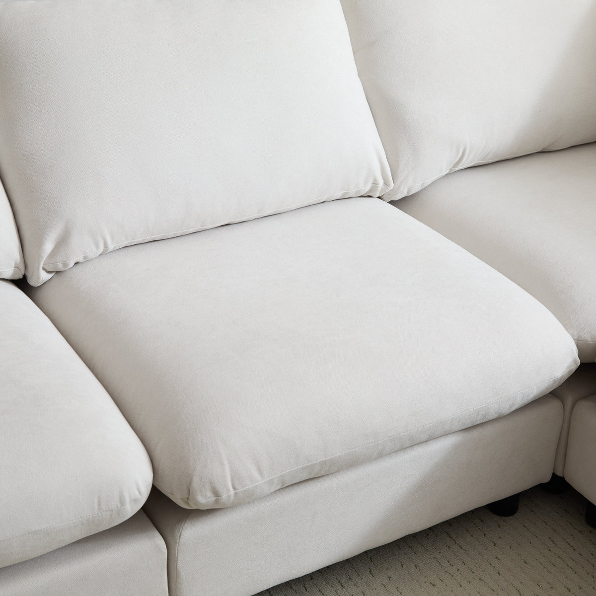 Close-up of white sectional sofa seat cushion with stitched arm seam
