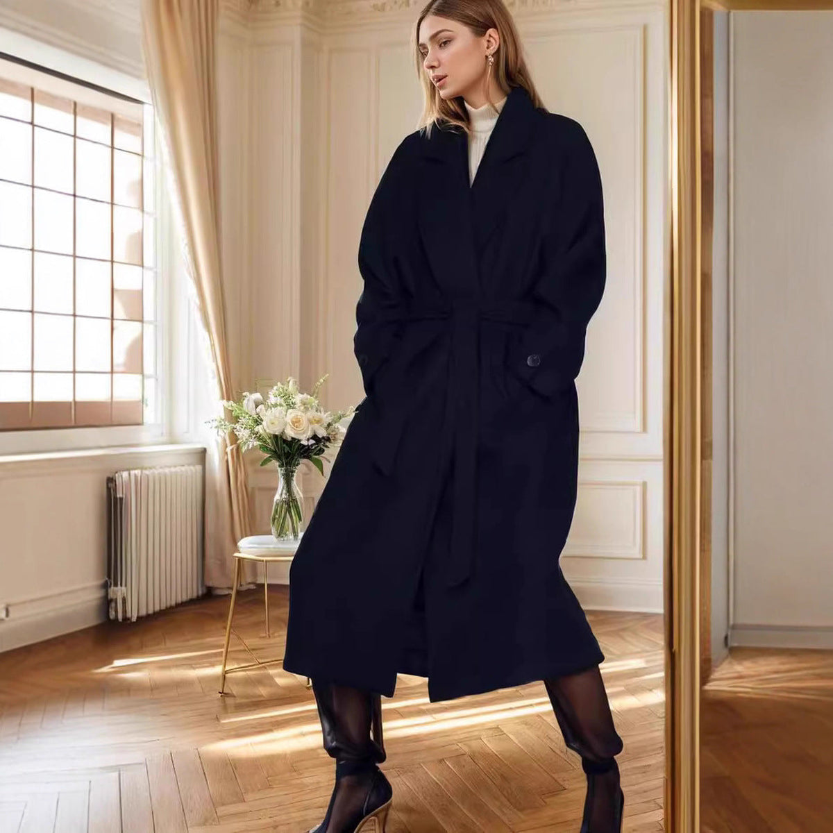 Women\'s dark navy wool coat with belted waist, long sleeves, and buttoned cuffs