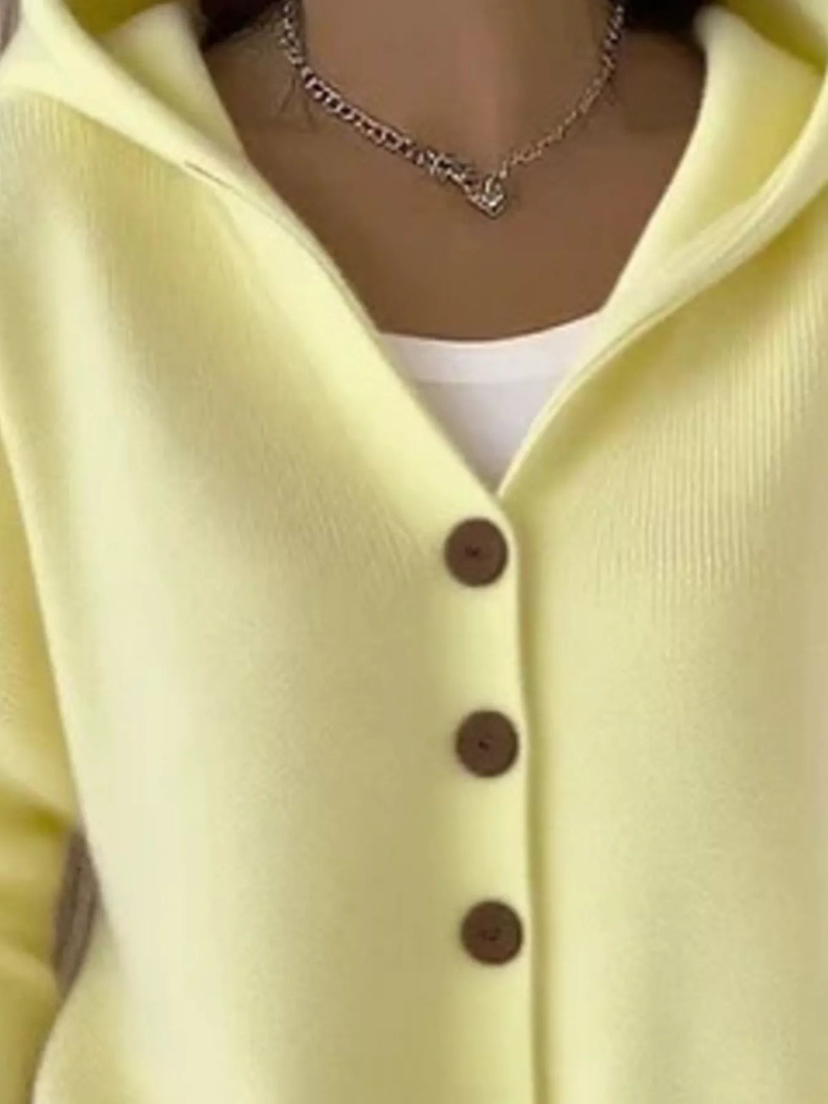 Light yellow hooded knit cardigan close-up, front buttons and V-neck