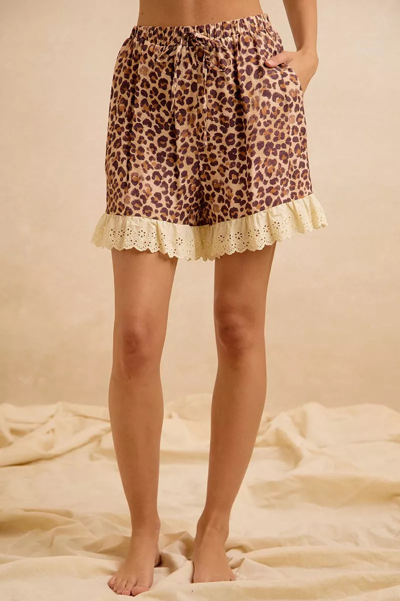 Leopard print shorts with eyelet lace ruffle hem, standing side view