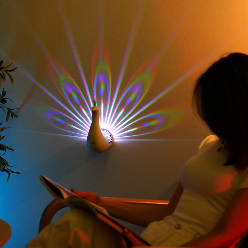 White peacock wall lamp emitting multicolor light rays toward the wall