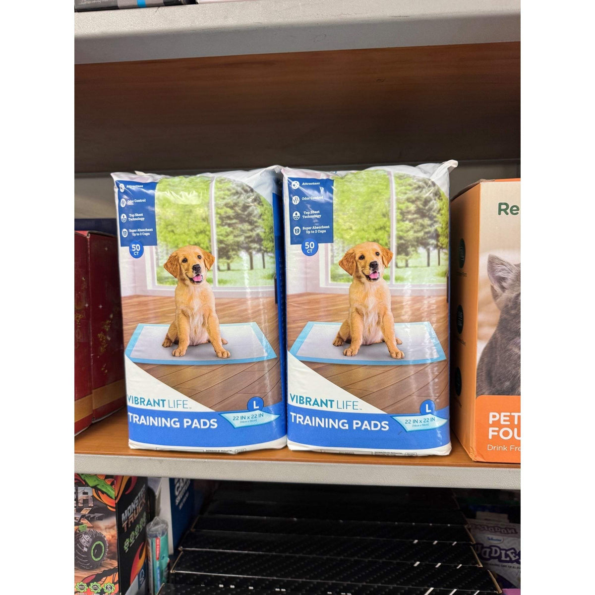 Dog training pads multipack display with blue-and-white packages and dog graphic