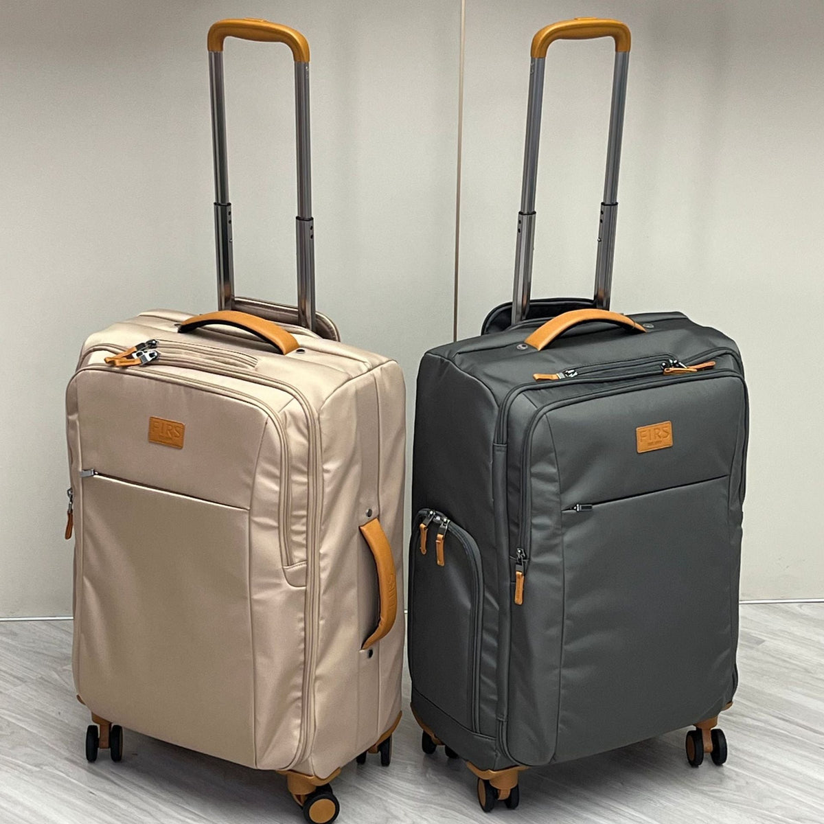 Pair of ultra-light wheeled trolley suitcases in light and dark gray with telescoping handle