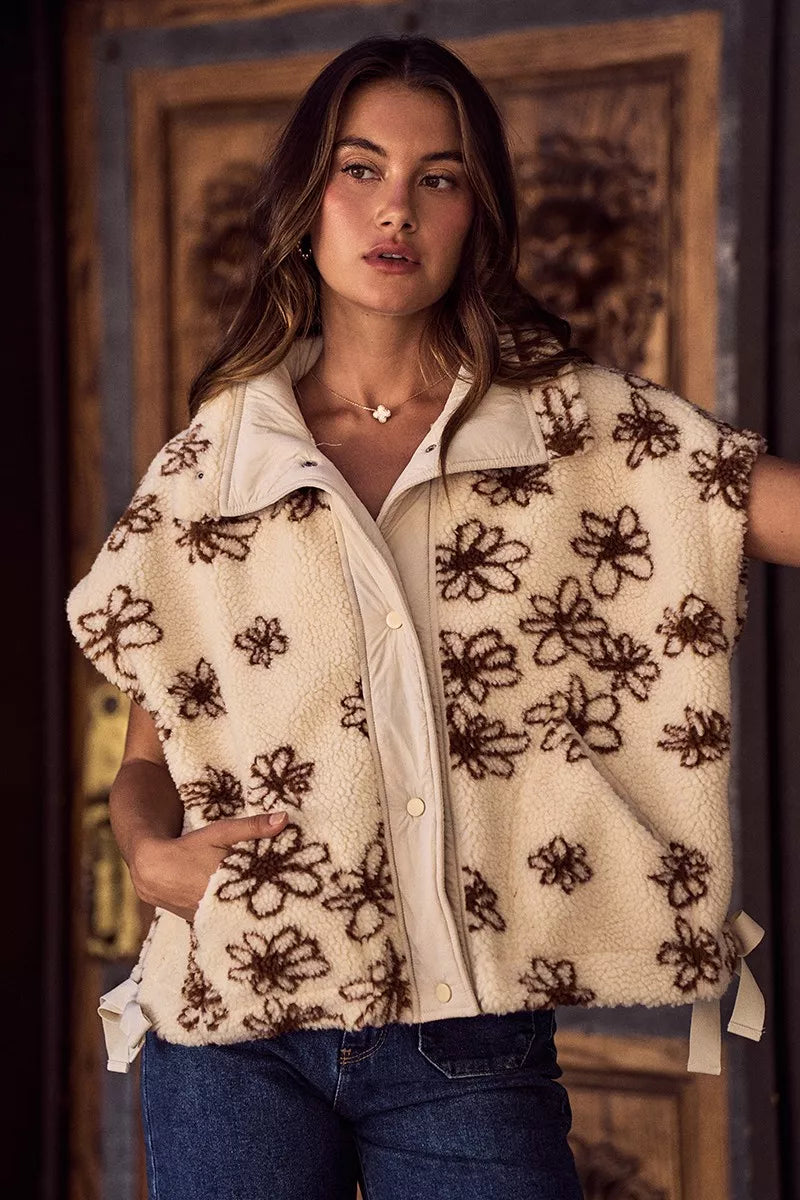 Oversized sleeveless sherpa vest jacket front view, cream with dark brown floral embroidery
