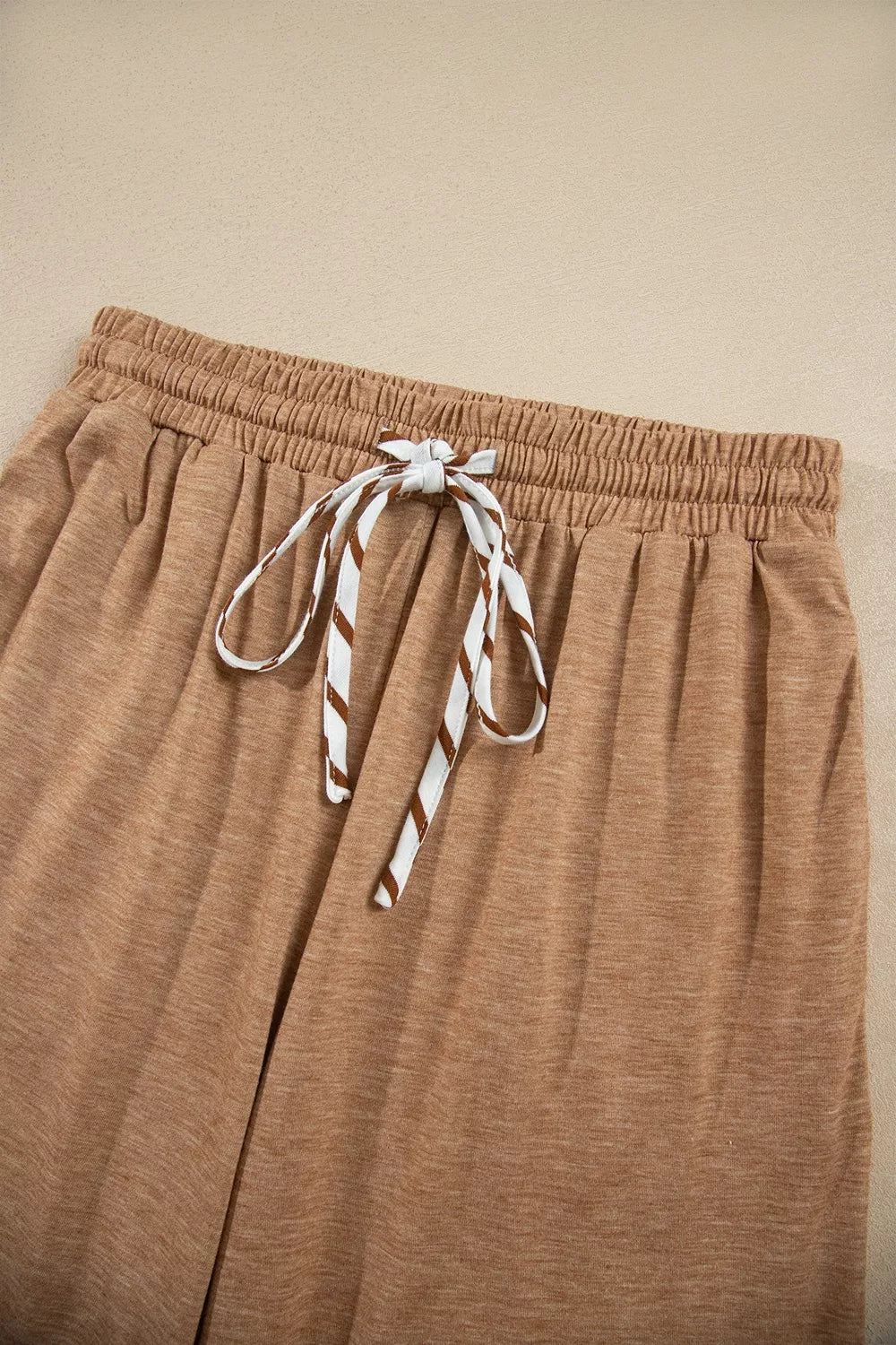 Camel drawstring pants with elastic waistband and striped tie detail