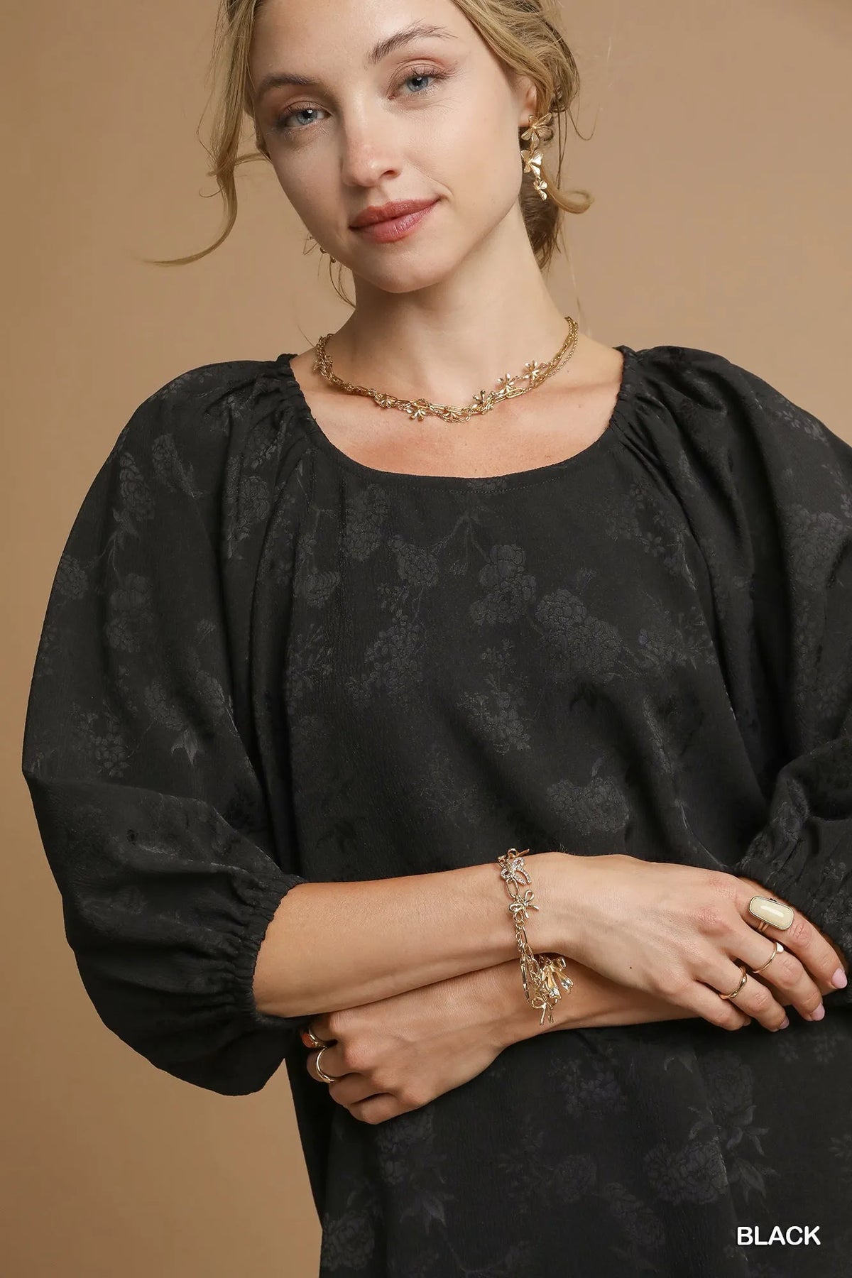 Black jacquard balloon-sleeve blouse close-up with round neckline and pattern