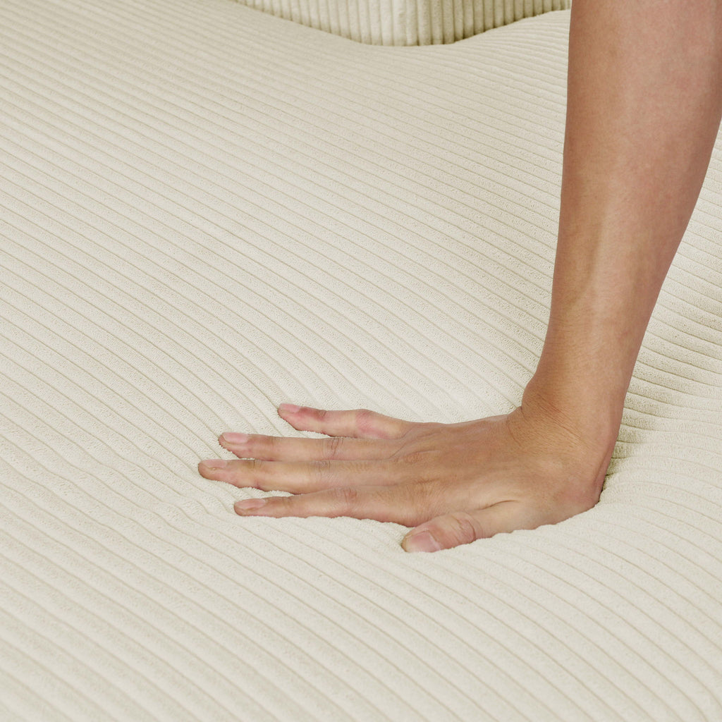 Beige corduroy upholstery close-up with hand pressing ribbed fabric