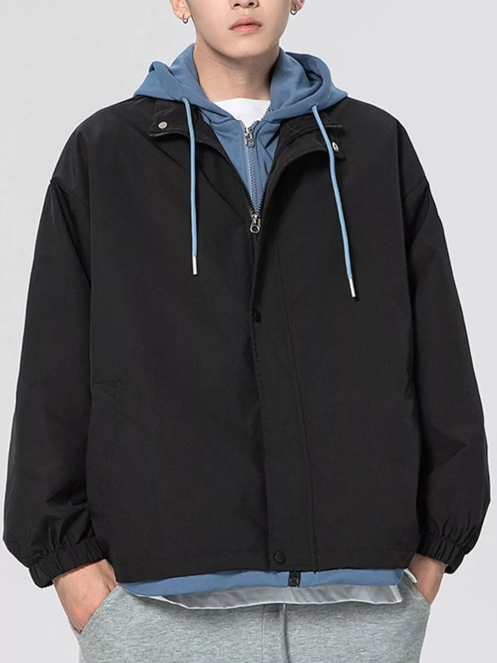 Black lightweight windbreaker jacket with hood, front zipper, and drawcord hem