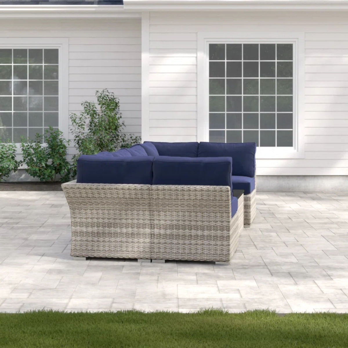 Wicker sectional sofa with navy seat cushions and gray woven coffee table