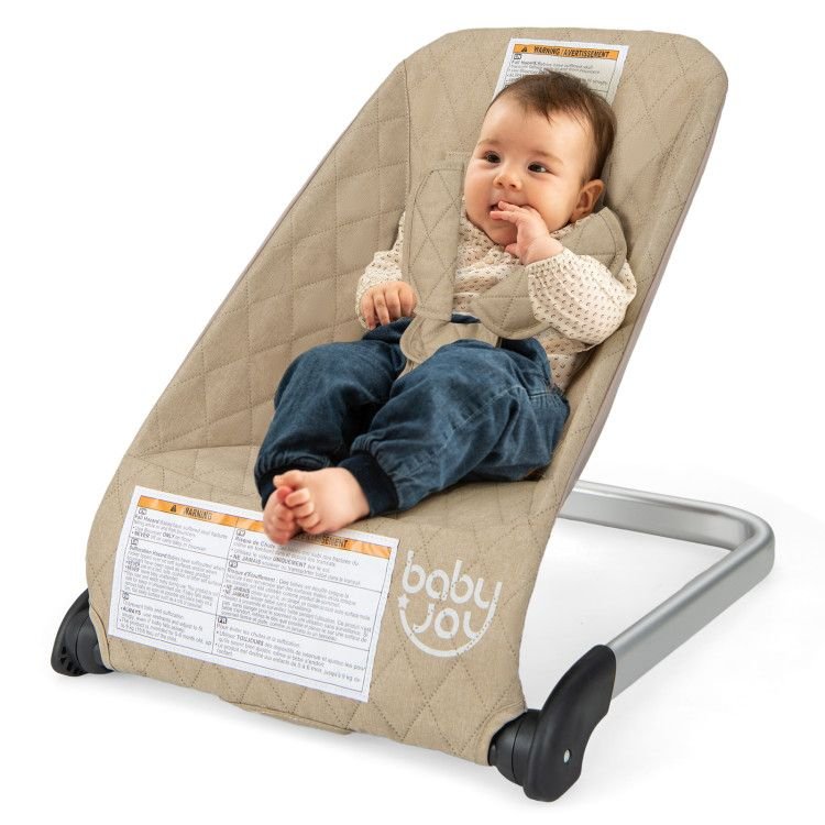 Baby bouncer seat in light beige fabric with black base and newborn in padded liner