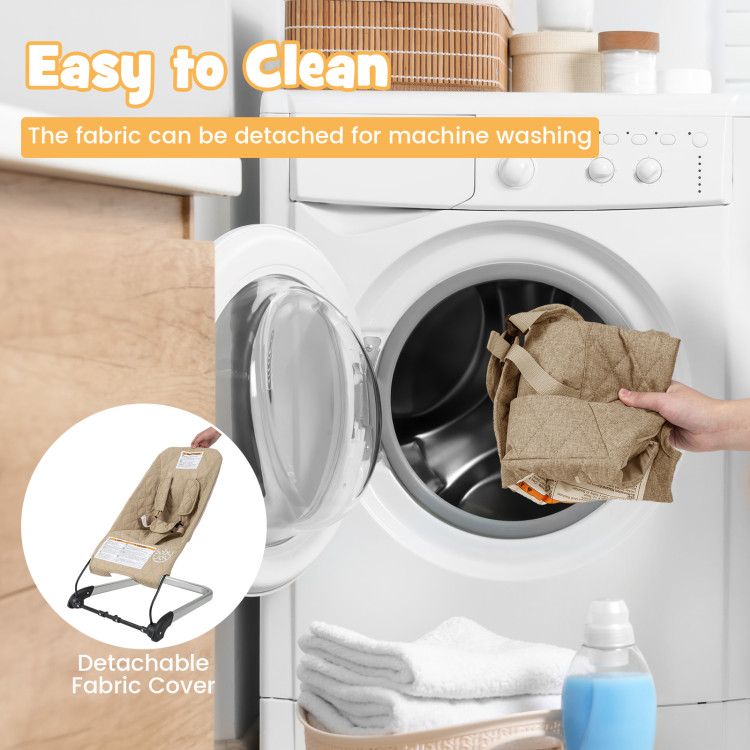 Baby bouncer seat with detachable light beige fabric cover being placed into a washing machine