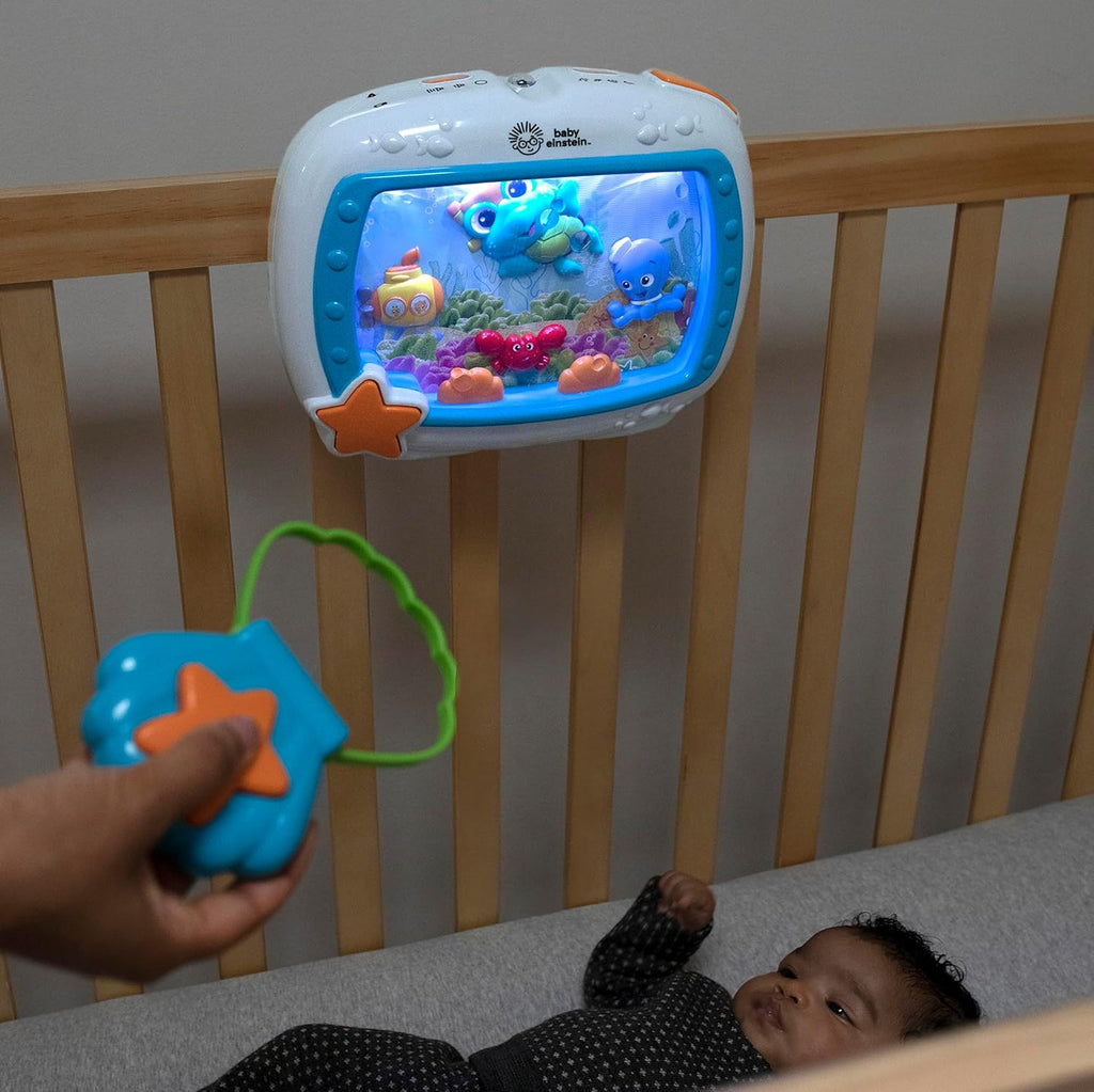 Blue sea dreams sound machine clipped to crib railing with star-shaped toy handle